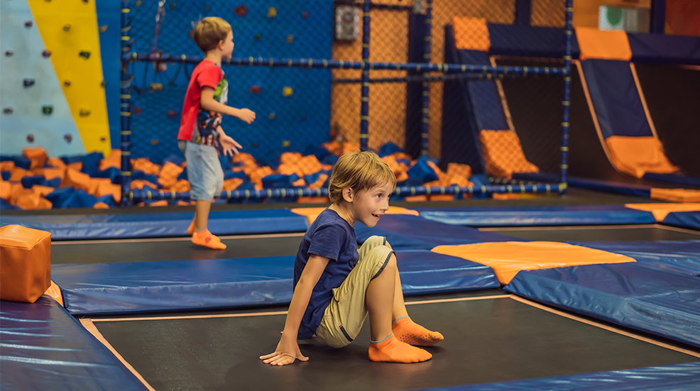 Cute boy jumping on trampoline in entertainment center 